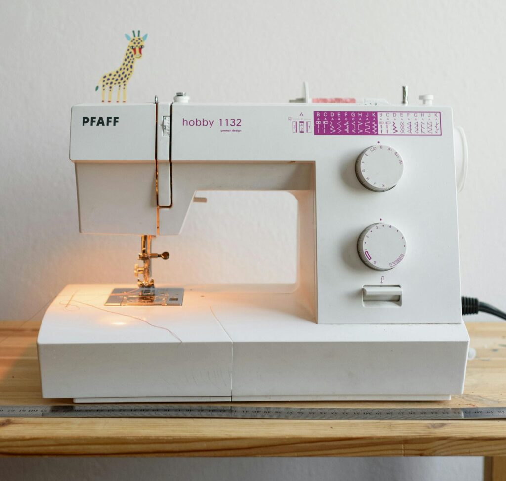 White Sewing Machine On Brown Wooden Table