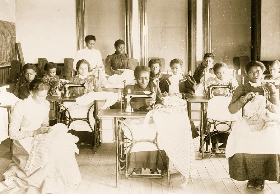 Historical photo of young women using sewing machines in sewing class