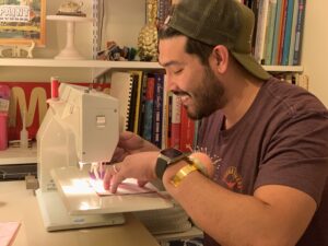 a smiling sewing students takes his first stitches on a Bernina 930.